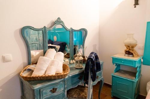ein Badezimmer mit einer blauen Kommode und einem Spiegel in der Unterkunft Casa do Poço Velho in Grândola