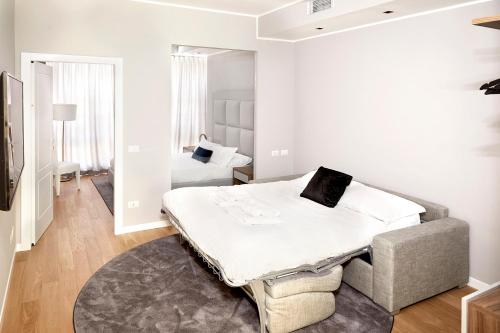 a white bedroom with a bed and a chair at PRESTIGE BOUTIQUE APARTHOTEL -Piazza Duomo in Milan