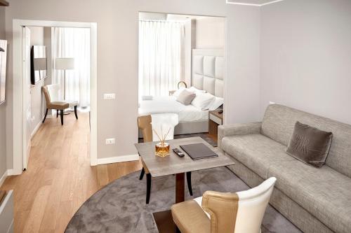 a living room with a couch and a bed at PRESTIGE BOUTIQUE APARTHOTEL -Piazza Duomo in Milan