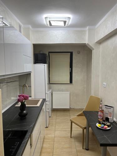 Il comprend une cuisine équipée d'un comptoir noir et d'un réfrigérateur blanc. dans l'établissement Central Apartament 2, à Iaşi