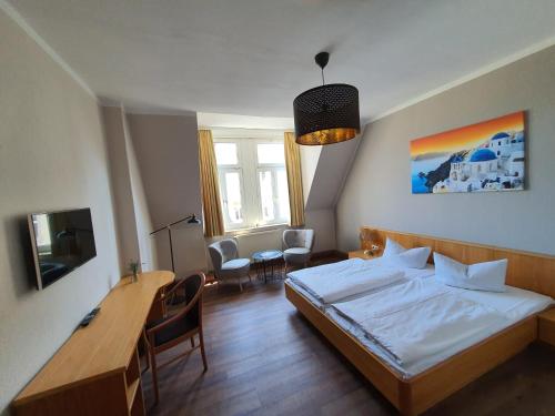 Schlafzimmer mit einem Bett, einem Tisch und Stühlen in der Unterkunft Hotel Friedensbruecke in Greiz