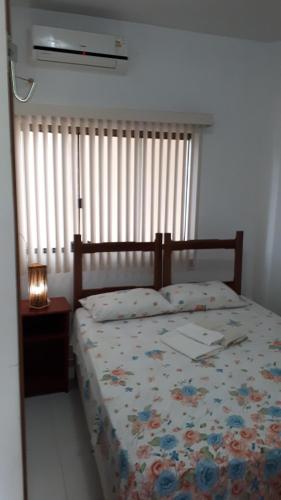 a bedroom with a bed and a window with blinds at Pousada Recanto do Japa in Nilo Peçanha