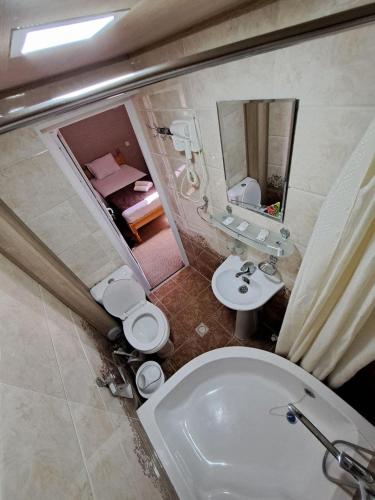 a bathroom with a white toilet and a sink at Bukhara Hotel Alikhan in Bukhara