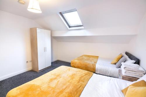 sypialnia na poddaszu z 2 łóżkami i świetlikiem w obiekcie Modern city centre flat with free parking w mieście Leeds