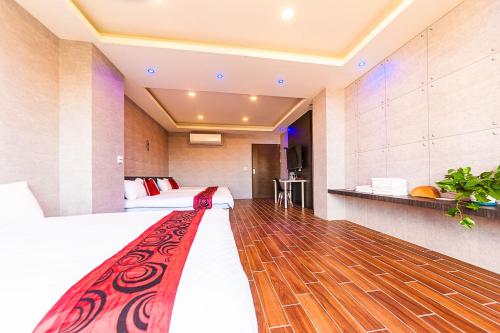 a hotel room with two beds and a wooden floor at 旅途之家 in Suao