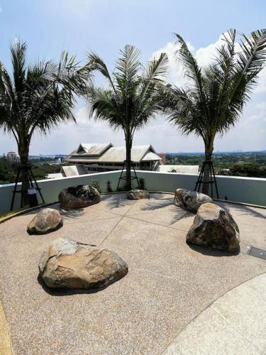 a view of rocks and palm trees and a building at Almas Muji Studio 100mbps Netflix STAY in Nusajaya