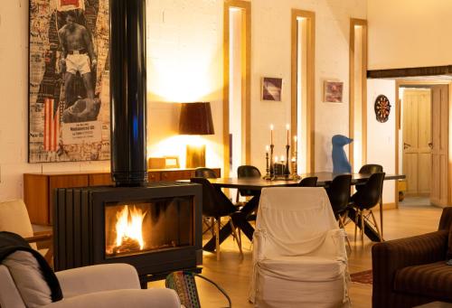 - un salon avec une cheminée, une table et des chaises dans l'établissement VILLA LE LOFT - CALME & DECO - Patio intime - Salle de Cinéma - Centre Ville, à Vannes