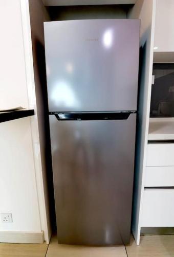 a stainless steel refrigerator in a kitchen at Almas Muji Studio 100mbps Netflix STAY in Nusajaya
