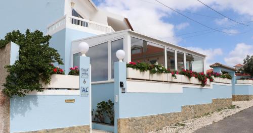 a blue and white house with flowers on the balcony at Villa da Praia in Sintra
