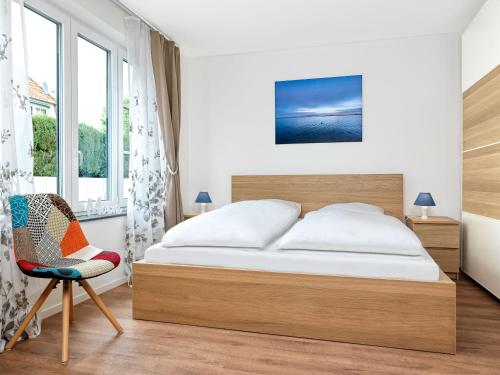 a bedroom with a bed and a chair at Windwatt in Gollwitz