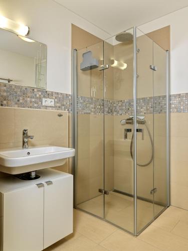 a bathroom with a glass shower and a sink at Windwatt in Gollwitz