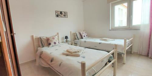 a bedroom with two beds and a mirror at Beach&Surf Flat in Aljezur