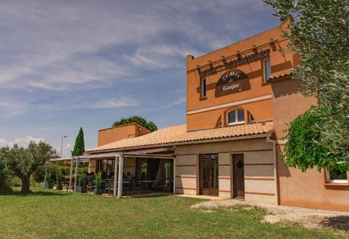 ein Gebäude mit einem Rasen davor in der Unterkunft Le Mas De Gaujac in Lézignan-Corbières