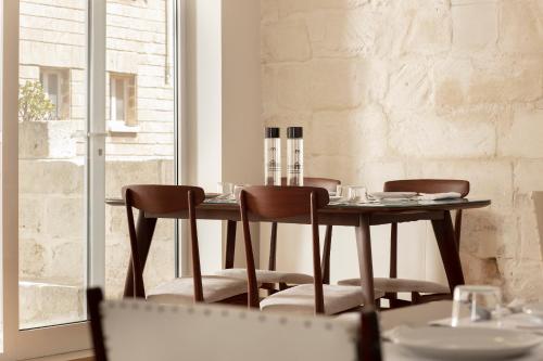a dining room table with four chairs and a window at Palazzo dei Tolomei in Lecce