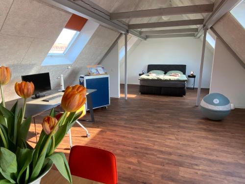 uma sala de estar com uma cama e uma secretária com um computador em Loft im Schleusenhaus em Hameln