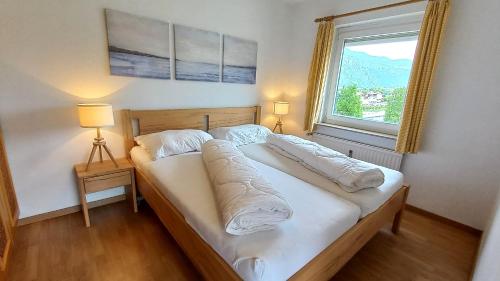 a bed in a room with a large window at KASPAR Haus KMB Seeblick Appartement am Ossiacher See mit direktem Seezugang, Hallenbad in Bodensdorf