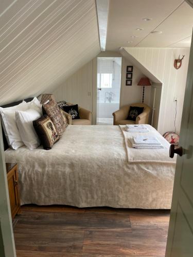 een slaapkamer met een groot bed op zolder bij The Rose in Mantgum