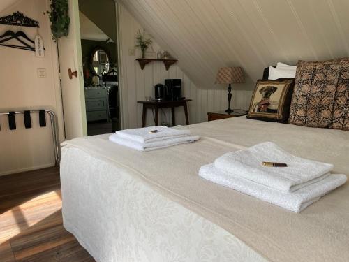 een slaapkamer met een bed met handdoeken erop bij The Rose in Mantgum