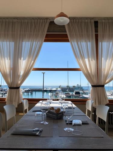 a dining room with a table and a large window at Albergo La Pescatrice in Moniga