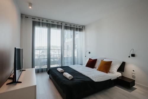 1 dormitorio con 1 cama grande y TV en Arcade - Apartment with a sunny view - A/C en Cracovia