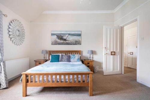 a bedroom with a wooden bed with blue pillows at St Anne's House in Plymouth