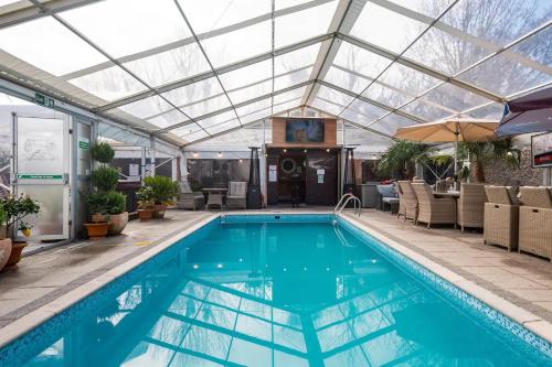 an indoor pool with a glass roof and a swimming pool at St Annes House in Plymouth
