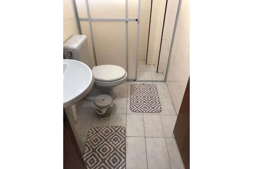 un baño con inodoro y lavabo en T004 - Apto na Tupi com sacada, garagem e ótima localização, en Samaritá