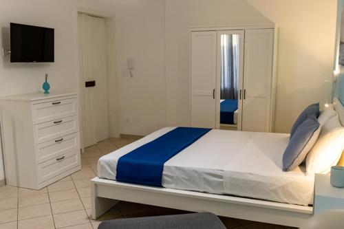 a white bedroom with a bed and a mirror at Blu Salina - Casa Vacanze in Margherita di Savoia