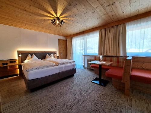 ein Schlafzimmer mit einem Bett, einem Tisch und einem Sofa in der Unterkunft Gästehaus Hochmuth in Mayrhofen