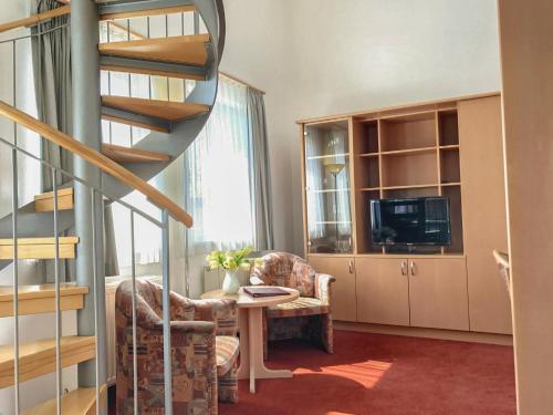 a living room with a spiral staircase and a table at Appartement-Hotel Sibyllenbad in Neualbenreuth