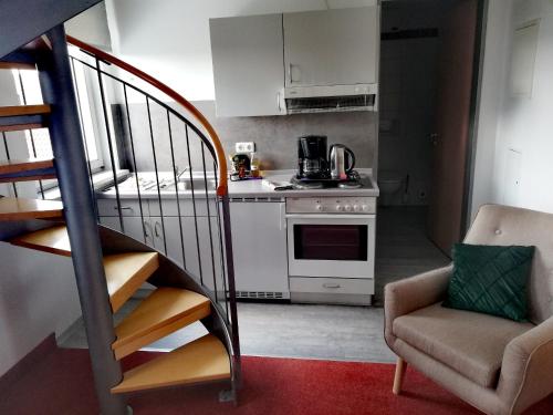 a kitchen with a staircase and a kitchen with a stove at Appartement-Hotel Sibyllenbad in Neualbenreuth