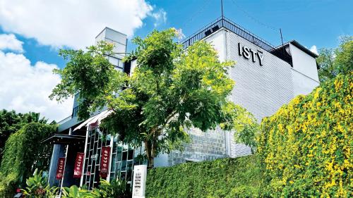 a tall white building with a sign on it at ISTY Design Hotel in Chiang Mai
