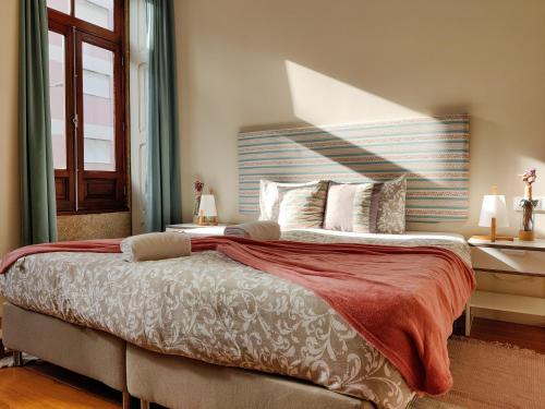 a bedroom with a large bed and a window at Sweet Swell in Porto