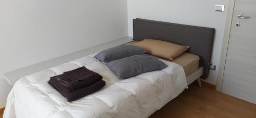 a bed with three pillows on it in a room at B&B Markone Bologna Center in Bologna
