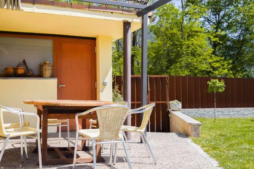 a patio with a table and chairs and a fence at Can ventura alojamiento entero in La Vall de Bianya