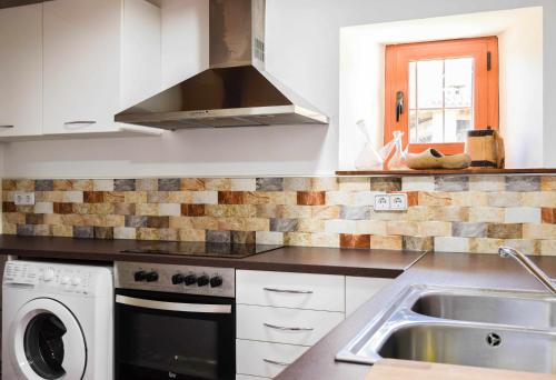 a kitchen with a sink and a stove at Can ventura alojamiento entero in La Vall de Bianya