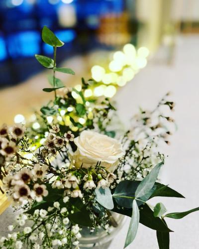 a vase filled with white flowers on a table at Hotel Bistrot FINE in Anglet