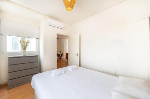 Dormitorio blanco con cama blanca y espejo en Monsanto Hill House - NO 571 1E, en Lisboa