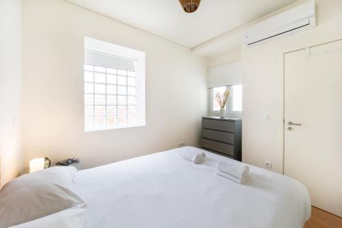 Monsanto Hill House - NO 571 1E في لشبونة: غرفة نوم بيضاء مع سرير أبيض ونافذة