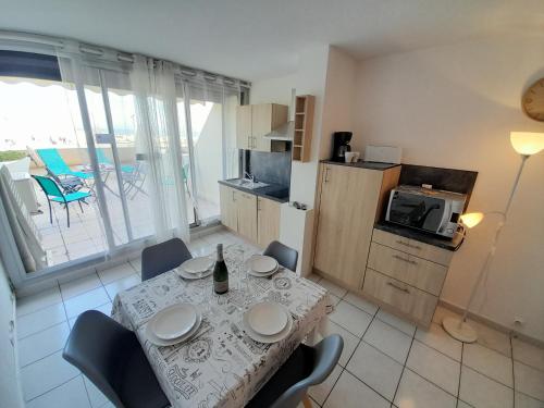 une cuisine avec une table et des chaises ainsi qu'une cuisine avec une table et une table dans l'établissement Appartement Village Naturiste Paradoxia, au Cap d'Agde