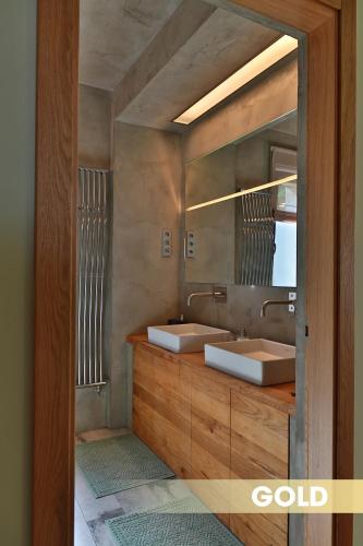 a bathroom with two sinks and a mirror at DV Premium Apartments in Siófok