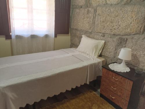 sypialnia z łóżkiem i kamienną ścianą w obiekcie D. Maria São Pedro de Balsemão w mieście Lamego