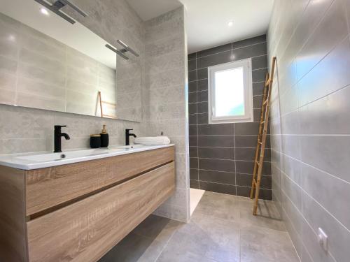 un baño con lavabo y espejo en Villa moderne , neuve piscine jacuzzi ., en Sarlat-la-Canéda