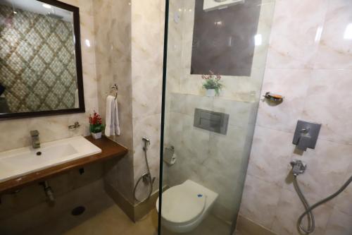 a bathroom with a shower and a toilet and a sink at Hotel Palm Grand Naraina New Delhi - Couple Friendly Local IDs Accepted in New Delhi