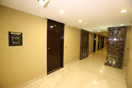 a hallway with black doors and a sign on the wall at Hotel Palm Grand Naraina New Delhi - Couple Friendly Local IDs Accepted in New Delhi