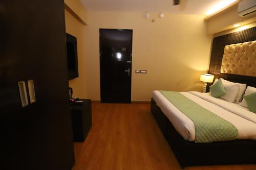 a hotel room with a bed and a black door at Hotel Palm Grand Naraina New Delhi - Couple Friendly Local IDs Accepted in New Delhi