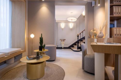 - un hall avec deux tables, un canapé et des escaliers dans l'établissement Hôtel Beige, à Paris