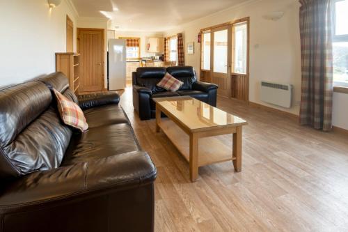 a living room with a leather couch and a coffee table at Portavadie Loch Fyne Scotland in Portavadie