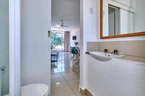 uma casa de banho com um lavatório e um espelho em Inn & Out Sandton Park em Joanesburgo
