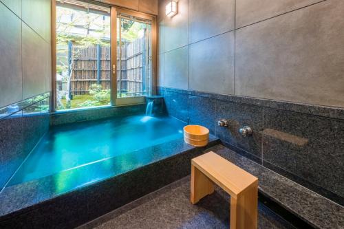 ein Badezimmer mit einer großen blauen Badewanne und einem Fenster in der Unterkunft 高野山 宿坊 恵光院 -Koyasan Syukubo Ekoin Temple- in Koyasan